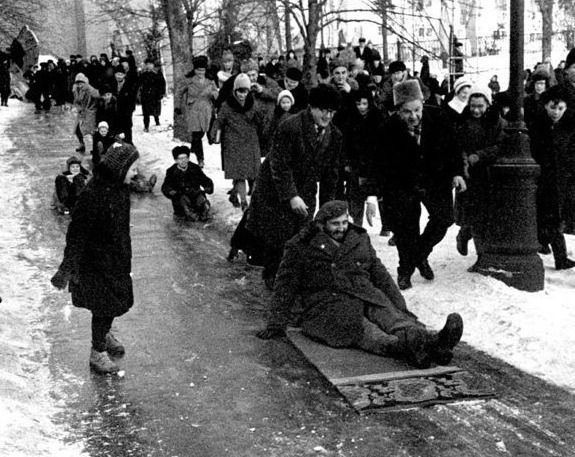 Фидель Кaстро съезжает с ледяной горки на ковре во время визита в Москву. Фото было сделано в январе 1964 года.