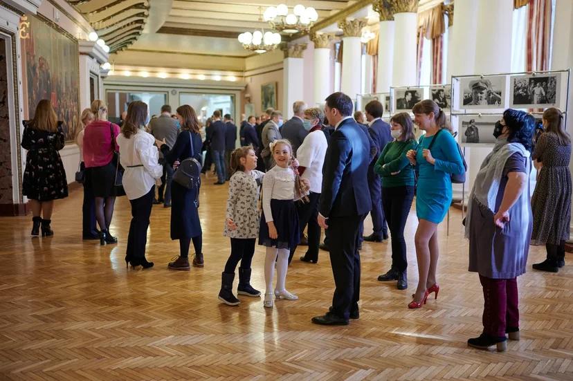 Люди в коридоре смотрят фотографии с Ю.А. Гагариным 