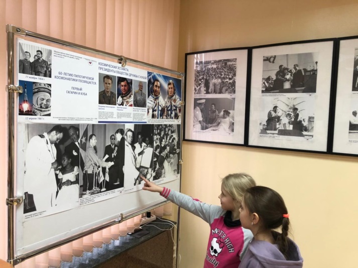 Посетители Тематического вечера «Юрий Гагарин – человек мира» рассматривают фотографии на стенде