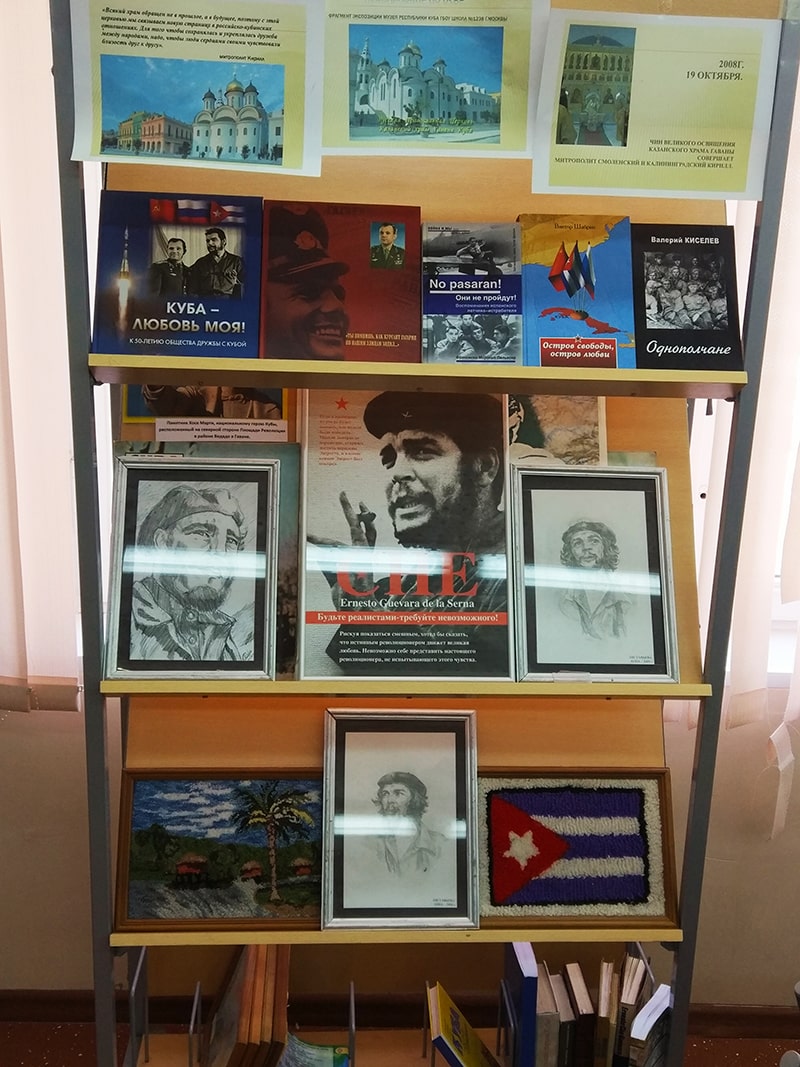 Стенд с Кубой на стене с картинами и книгами