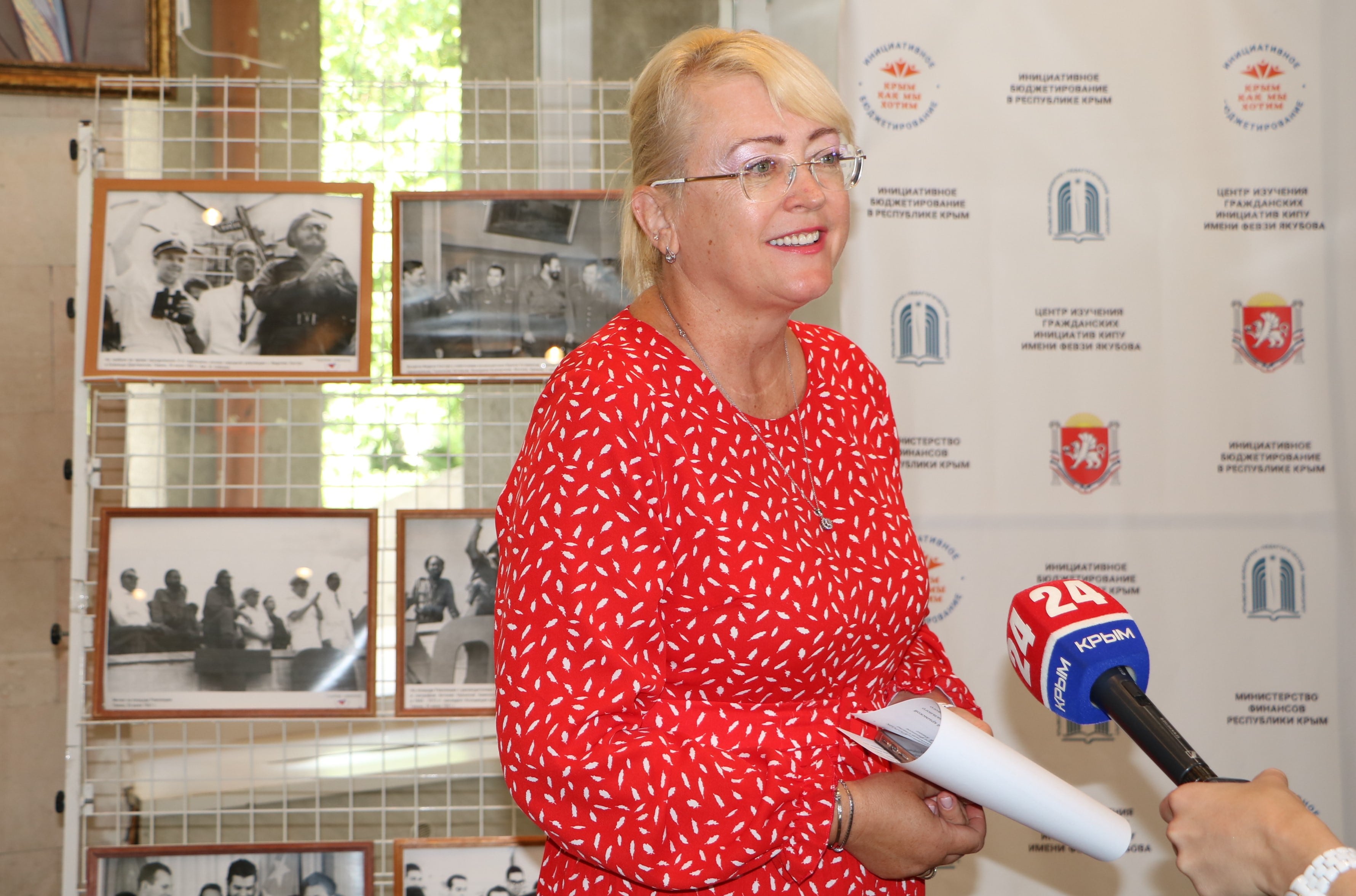 На фото: Ирина Кивико в красном сарафане дает интервью местному телеканалу.