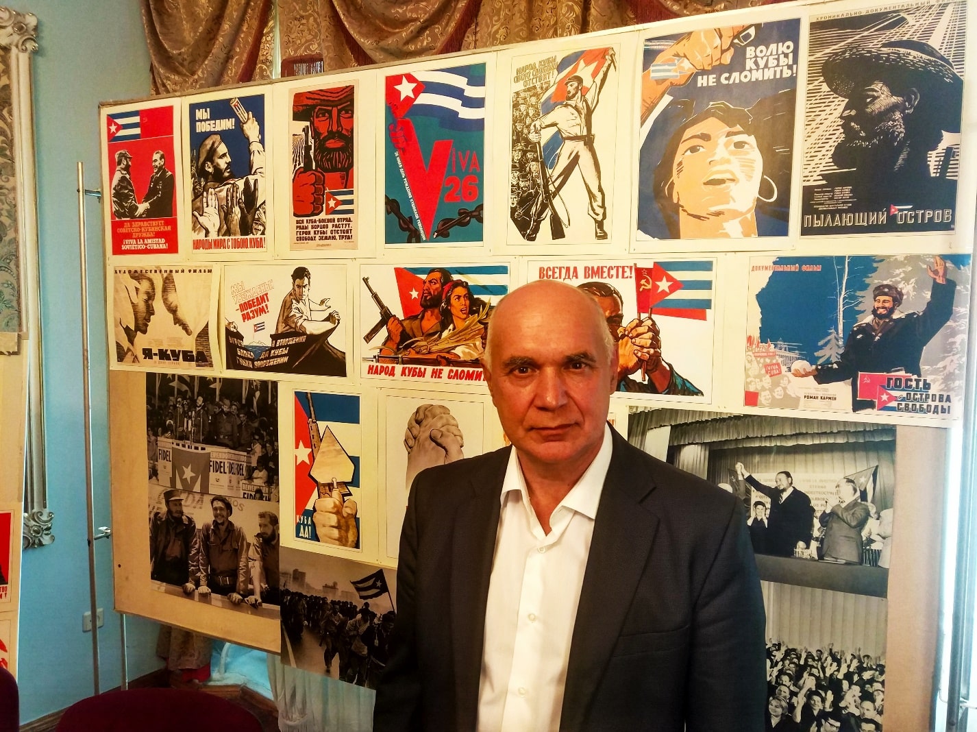 На фото:Николай Егорович Мануйлов на фоне стенда с карикатурными плакатами