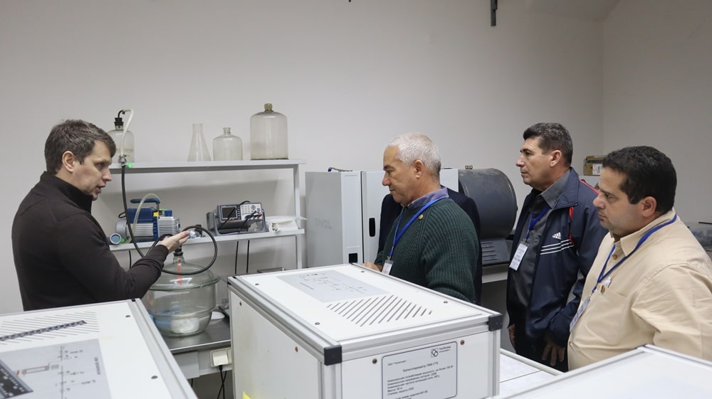 Мужчина показывает кубинским коллегам приборы в из нефтегазовой отрасли
