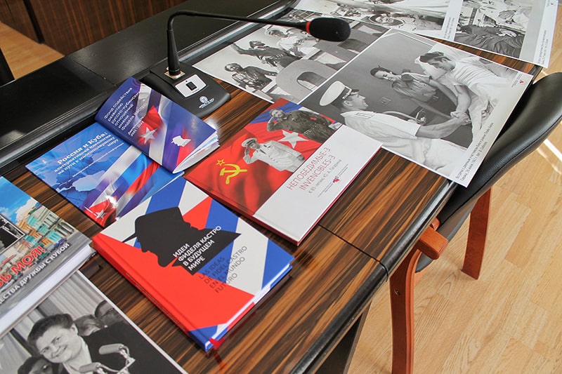 На столе разложены книги и фото связанные с дружбой СССР и Кубы
